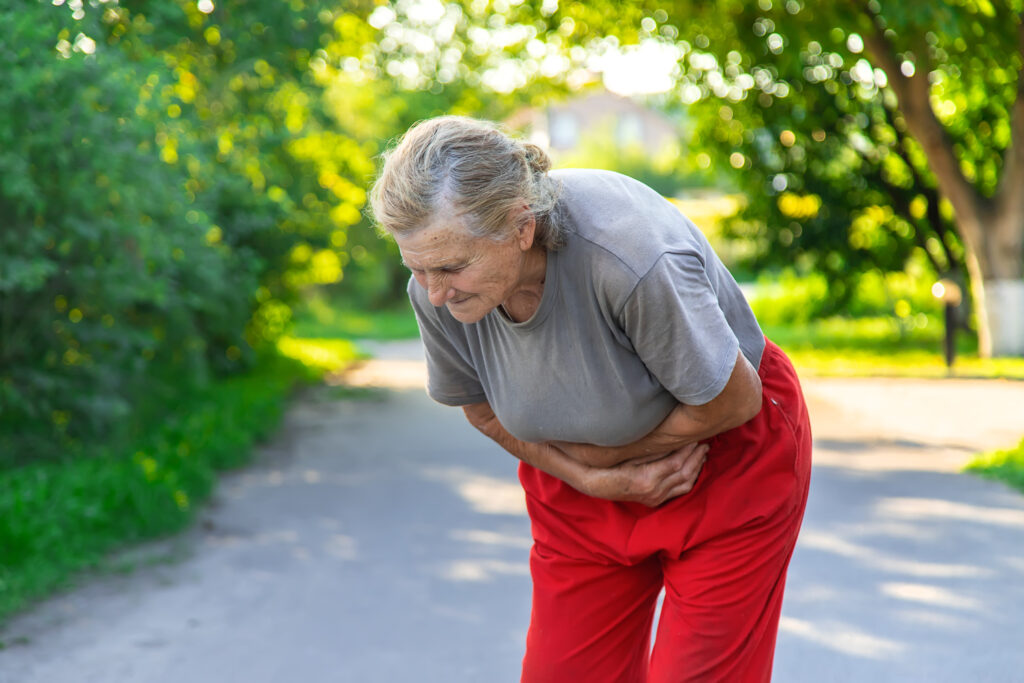Mulher idosa sentindo fortes dores devido a gases intestinais